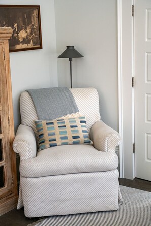 Relax in a cozy sitting area with a plush armchair, matching ottoman, and a stylish floor lamp.