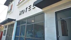 Eine Hotelscheune mit auffälligem Schild, großen Fenstern und einem Maschendrahtgitter.