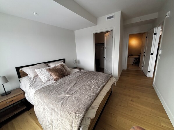 Un dormitorio con cama, mesitas de noche y vestidor.
