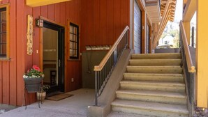 Un bâtiment en bois avec un escalier menant à un garage.