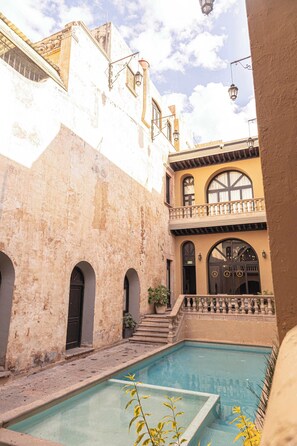 Surrounded by traditional architecture, this serene courtyard features a central swimming pool.