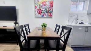 A dining area with a wooden table, black chairs, and a floral painting on the wall. - New Private Spacious & Modern Apartment near Square One and Downtown Mississauga (Mississauga)