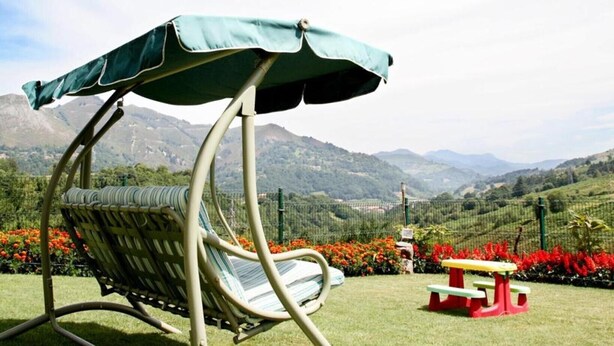 A garden chair with a canopy, a picnic table, and a view of mountains. - Holiday Home 'Supereda' with Mountain View, Private Terrace and Wi-Fi (San Juan de Parres)