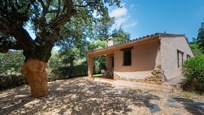 A rustic house with a covered patio, surrounded by trees and a clear sky. - Rural House El Chopo with Mountain Views, Terrace, Shared Pool, and Parking (Alajar)