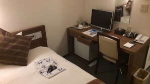 A hotel room with a bed, a desk with a computer, a chair, a telephone, and a waste bin. - HOTEL KUNIMI KAMONOMIYA (Odawara)