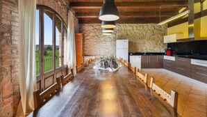 A spacious kitchen with a long wooden table, stone walls, and large windows. - Country House 'Casamira' with Mountain View, Private Pool and Wi-Fi (Unknown)