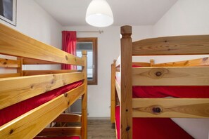 A bunk bed room with wooden frames and red bedding. - Apartment 'Cerdagne' with Mountain View, Shared Terrace and Wi-Fi (Les Angles)