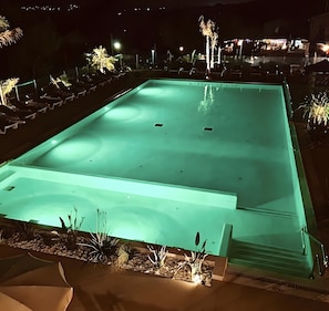A swimming pool with a tiled deck, surrounded by lounge chairs and plants. - Bungalow 'Sunset Lodge' with Sea View, Shared Pool and Air Conditioning (Saint-Raphaël)