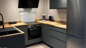 Een moderne keuken met een inbouwoven, een koelkast en een magnetron.