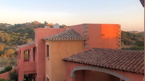Ein Gebäude mit roter Fassade, einem Ziegeldach und einem steinernen Bogen.