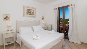 Ein ordentlich eingerichtetes Schlafzimmer mit Bett, Nachttischen und Blick durch ein Fenster.