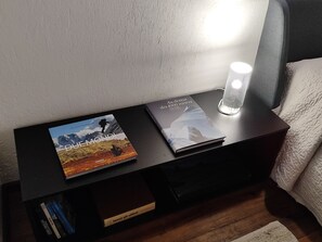 A bedside table with two books, a lamp, and a pillow. - Apartment 'Mini House' with Mountain View, Private Terrace and Private Garden (Roisan)