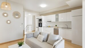 Un apartamento moderno con zona de estar, kitchenette y comedor.