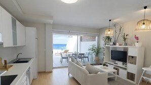 Una cocina moderna con comedor, un sofá y una televisión.