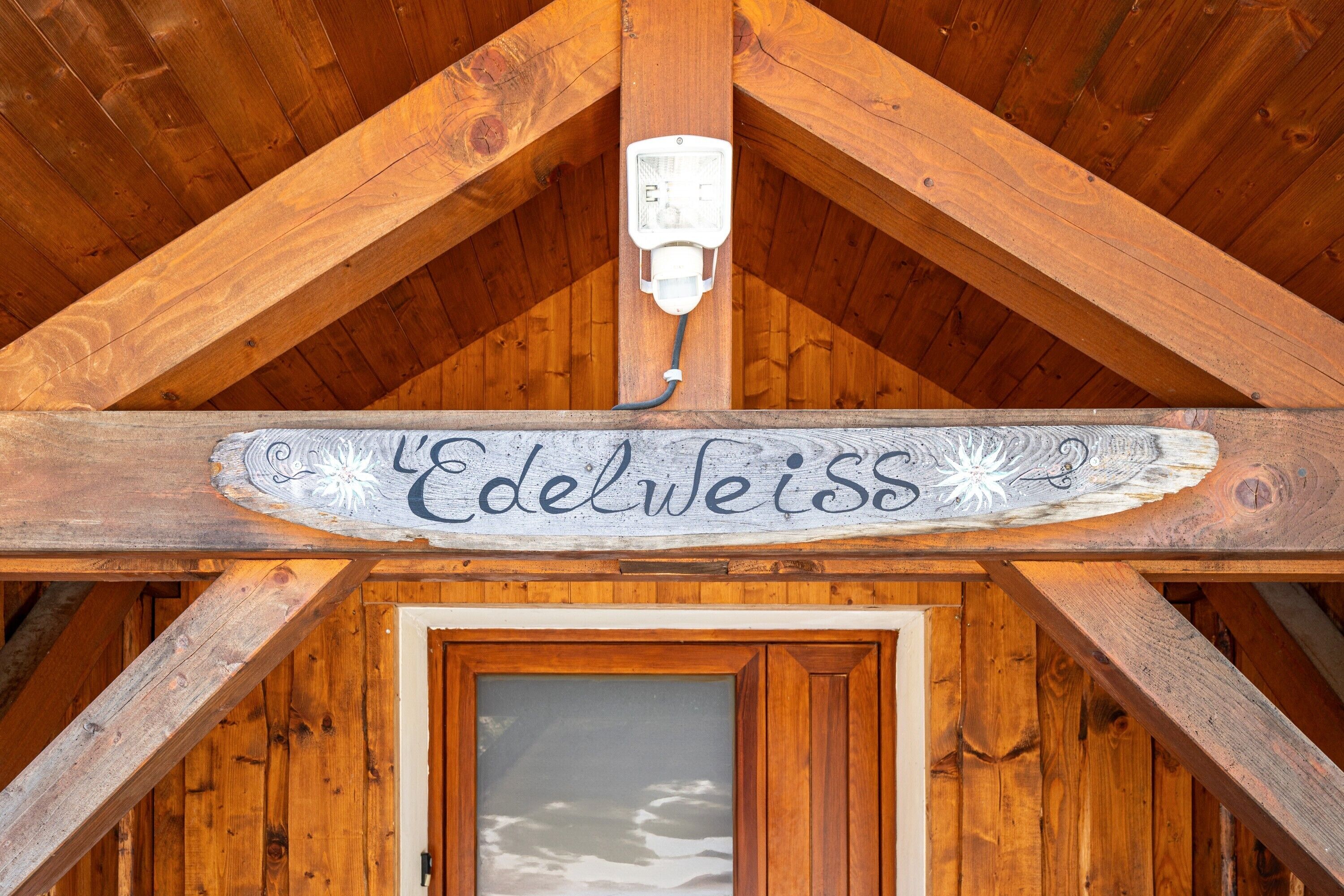 A wooden ceiling with a sign reading 'Edelweiss' and a power outlet.