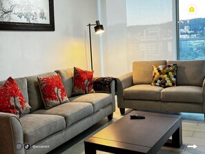 Departamento familiar, balcón, vista a la ciudad | Área de sala de estar | Televisión de pantalla plana 