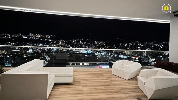 A modern balcony with a city view at night. - 3 Dormitorios en el Edificio ONE Quito (Quito)