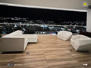 A modern balcony with a city view at night. - 3 Dormitorios en el Edificio ONE Quito (Quito)
