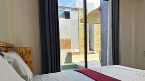 Una camera d'hotel con un letto, vista esterna e un balcone.