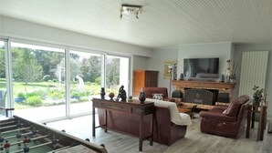 A living room with a foosball table, a TV, and a fireplace. - Les Treilles Saint Hilaire de Riez (SAINT HILAIRE DE RIEZ)