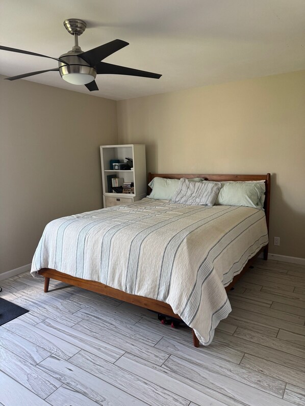 A bedroom with a bed, a ceiling fan, a bookshelf, and a wooden floor. - Wildwood Regional Park House - World Cup Ready --75 Miles to SoFi (Thousand Oaks)