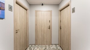 A hallway with two wooden doors, numbered 4 and 5, and a security camera above the central door.