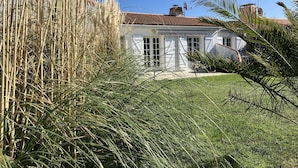A white house with a red-tiled roof, surrounded by tall grasses and a well-maintained lawn. - Frégate Saint Hilaire de Riez (SAINT HILAIRE DE RIEZ)