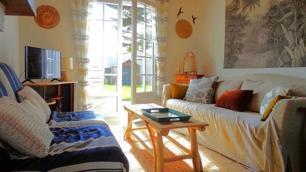 A living room with a sofa, a coffee table, a TV on a stand, and a painting on the wall. - Frégate Saint Hilaire de Riez (SAINT HILAIRE DE RIEZ)