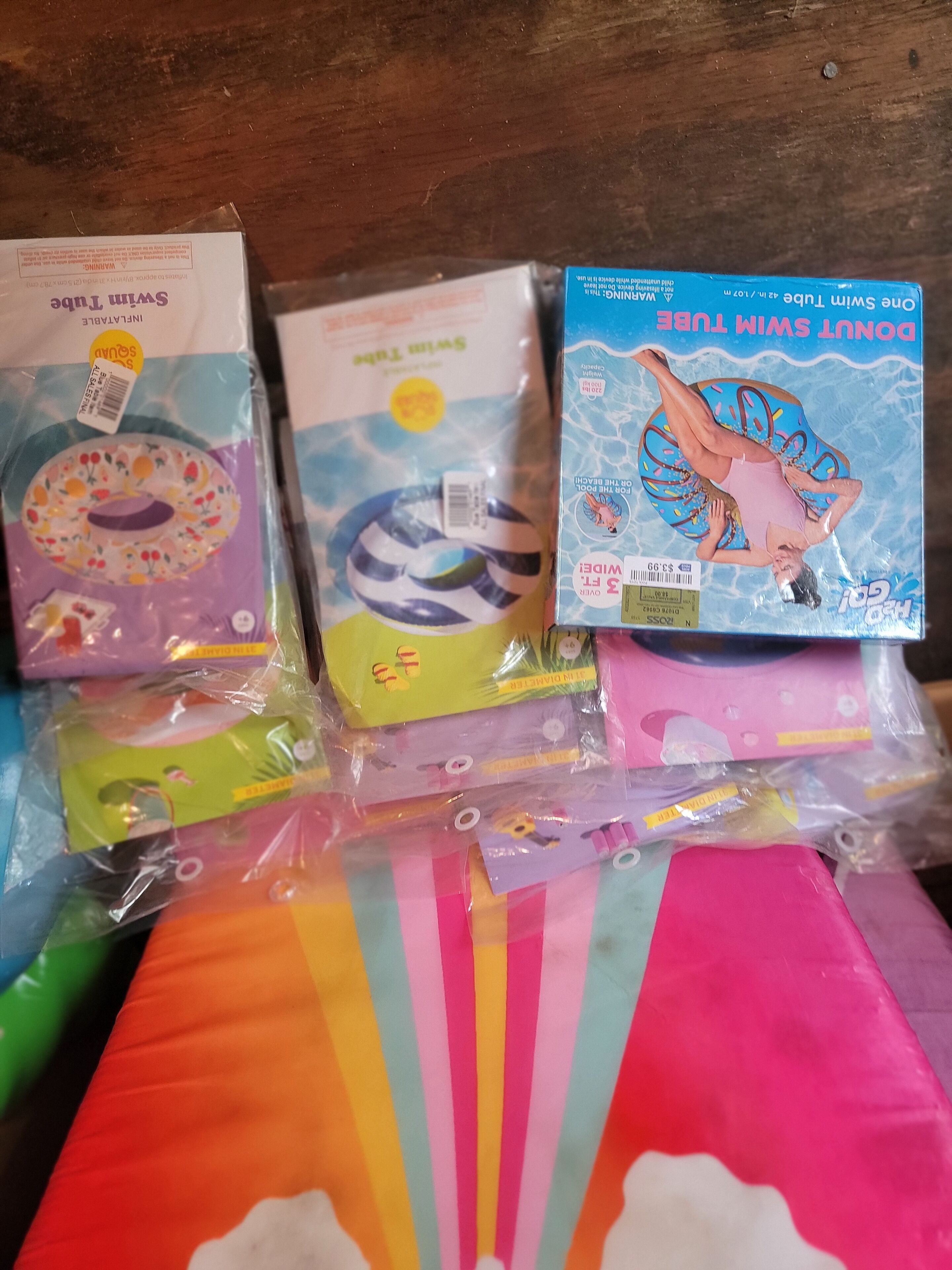 Un conjunto de flotadores de colores para niños y un objeto de tela con rayas de arcoíris.