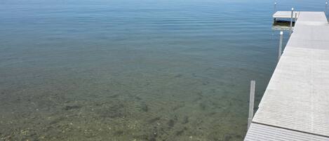 A clear view of a calm lake with a wooden dock extending into the water.