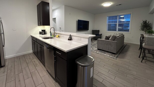 A modern kitchen with dark cabinets, a white countertop, and a stainless steel trash can. - Welcome to outlet Charming townhome with WiFi and AC & more in enjoyable Bayonne (Bayonne)