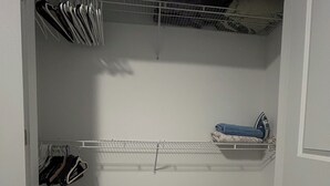 A walk-in closet with a metal shelf, a bench, and hanging storage. - Welcome to outlet Charming townhome with WiFi and AC & more in enjoyable Bayonne (Bayonne)
