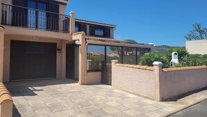 A two-story house with a covered patio, a garage, and a clear blue sky.