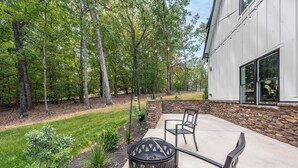 A patio with a fire pit, outdoor furniture, and a stone wall.
