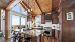 Una cocina amplia con una isla grande, armarios de madera y vistas al exterior.