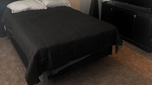 A hotel room with a large bed, a flat-screen TV, a bedside table, and a lamp. - Charming 2bedroom house with WiFi, AC in peaceful Indianapolis. Quiet cul-de-sac (Indianapolis)