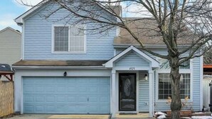 A two-story house with a garage, a front door, and a small porch. - Charming 2bedroom house with WiFi, AC in peaceful Indianapolis. Quiet cul-de-sac (Indianapolis)