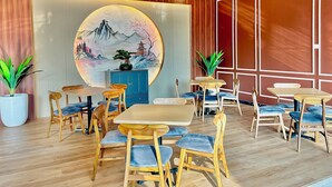 Un restaurant doté d’un plancher en bois, de tables rondes et de chaises rembourrées de tissu bleu.