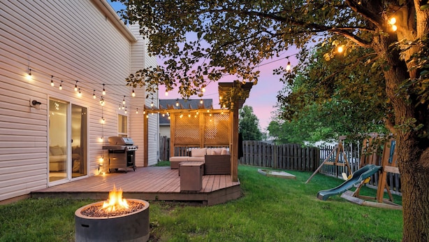 Un jardin avec un foyer, du mobilier d’extérieur et une terrasse en bois.