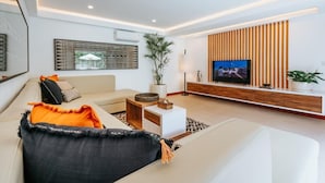 Un salon moderne avec un canapé, une table basse et un téléviseur.