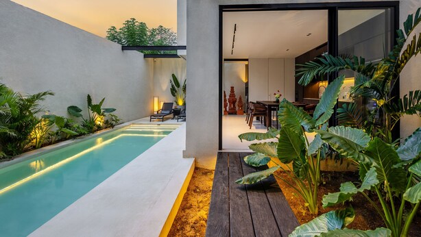 A modern house with a swimming pool, a wooden deck, and a dining area. - Villa Sabilla Bingin (Pecatu)
