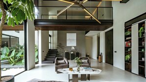 A spacious living area with a high ceiling, modern furniture, and a view of the outdoors. - Villa Sabilla Bingin (Pecatu)