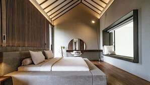 A modern bedroom with a large bed, wooden flooring, a skylight, and a large window. - Villa Sabilla Bingin (Pecatu)