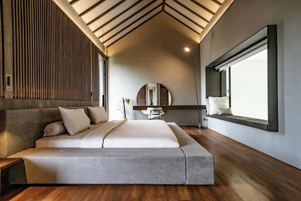 A modern bedroom with a large bed, wooden flooring, a skylight, and a large window. - Villa Sabilla Bingin (Pecatu)