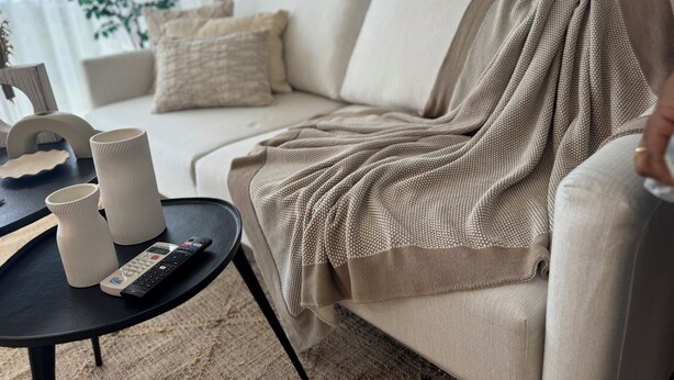 A living room with a sofa, a coffee table, and a blanket. - Xuite Home One Bedroom Suite (Punta Cana)