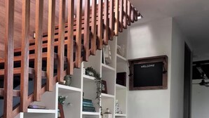 A modern interior with a white console table, wooden slats, and a welcome sign. - Fraser Coast, Eco Container Home + Cabin, Pool, Pet Friendly, Boat Ramp 5min (River Heads)
