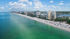 Eine Küstenstadt mit breitem Strand, klarem blauen Wasser und einer Reihe von Hotels an der Uferlinie.