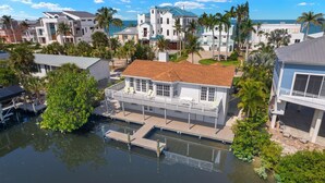 A waterfront property with a dock, a covered deck, and a view of the ocean. - Beach Dayz | Walk to Beach, Restaurants, Boat Dock & More (Bonita Springs)