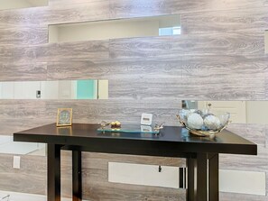A reception desk with a modern design, featuring a dark wooden table and matching dark wooden legs.