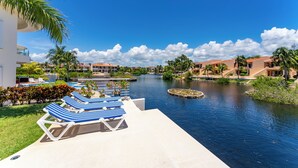 Um resort com piscina, espreguiçadeiras e um canal.